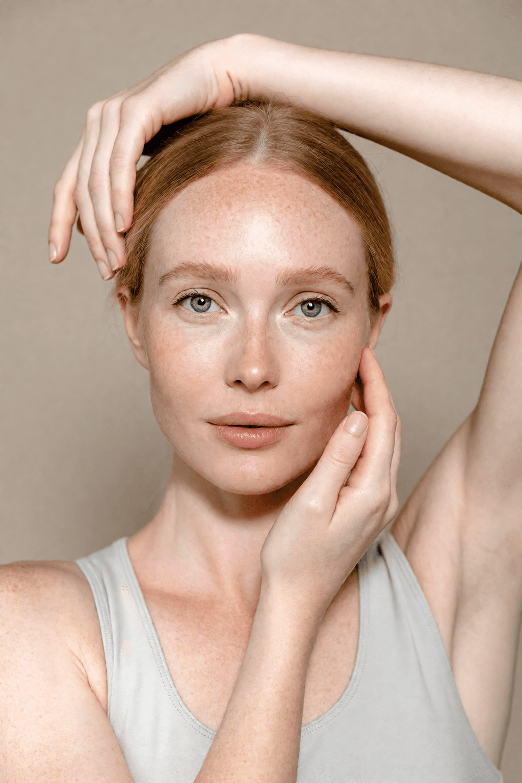 Pulled back, hands in frame: Out of distribution. A smaller face keeps its texture, and the hands hold their own skin detail rather than going smooth.